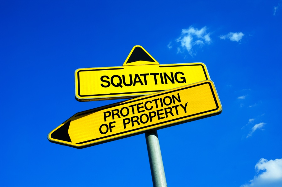 Two yellow street signs stacked with arrows pointing in different directions with the word squatting pointing one direction and protection of property pointed the other.